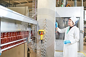 Factory worker operating conveyor with plastic bottles