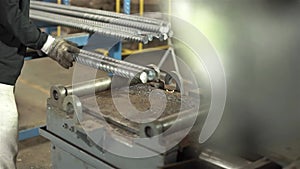 Factory Worker Placing 2 Steel Rods On A Machine