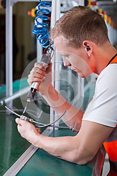 Factory worker with pneumatic screwdriver