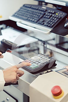 Factory worker pressing the OK button on a machine