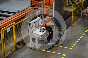 Factory worker programming CNC machine in metalworking workshop