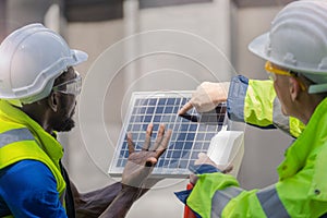 Factory worker technician engineer men showing and checking solar cell panel for sustainable technology with working suit and