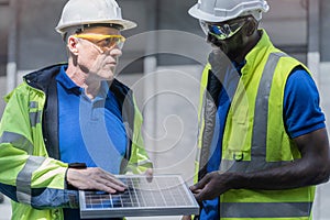 Factory worker technician engineer men showing and checking solar cell panel for sustainable technology with working suit and