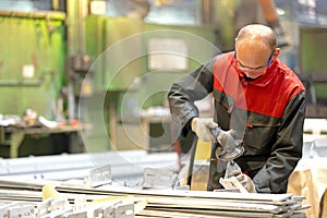 Factory worker using angle grinder during manufacture process