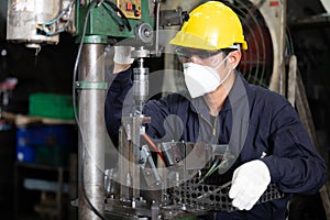 Factory worker wearing face mask for protect virus, using the machine in factory