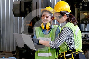 Factory worker women discuss together with laptop in workplace area. Concept of good teamwork and management system help and