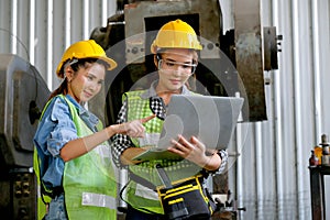 Factory worker women discuss together with laptop in workplace area. Concept of good teamwork and management system help and