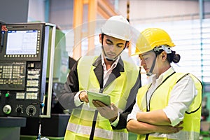 Factory workers check microchip stock in tablet by machinery