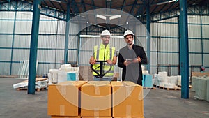 Factory workers deliver boxes package on a pushing trolley in the warehouse .