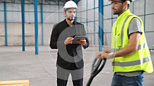 Factory workers deliver boxes package on a pushing trolley in the warehouse .