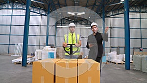 Factory workers deliver boxes package on a pushing trolley in the warehouse .