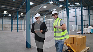 Factory workers deliver boxes package on a pushing trolley in the warehouse .