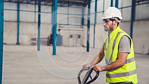 Factory workers deliver boxes package on a pushing trolley in the warehouse .