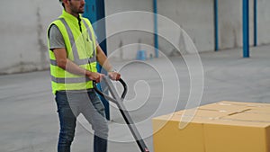 Factory workers deliver boxes package on a pushing trolley in the warehouse .