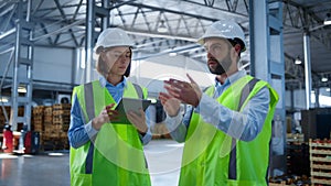 Factory workers discussing tablet information analysing production process