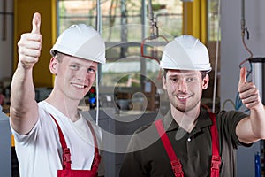 Factory workers giving thumbs up sign