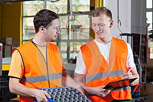 Factory workers in orange protective vest