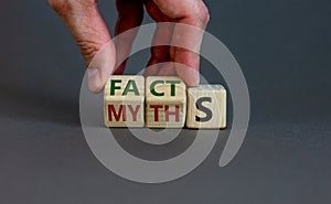 Facts or myths symbol. Businessman hand turns cubes and changes the word `myths` to `facts`. Beautiful grey background, copy s