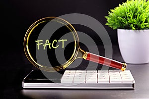 Facts, truth or accurate information in media news or business concept. FACT through the lens of a magnifying glass in the dark photo