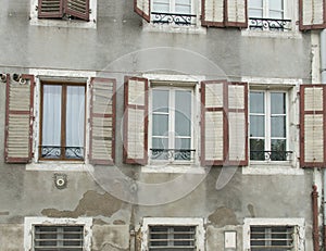 Faded red and white shutters on old building