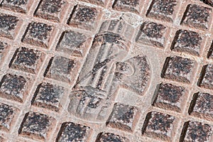 Faded symbol of Fascism on a manhole of the sewer or water system