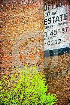 Fading ad fragment on a red brick wall