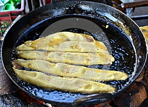 Fafda -gujrati snack breakfast being fried in a shop photo