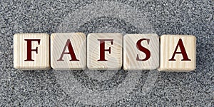 FAFSA - acronym on wooden cubes on a gray background