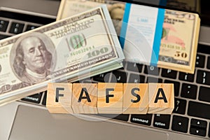 Fafsa. Student aid statement form and money on the tablet.