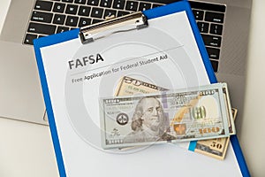 Fafsa. Student aid statement form and money on the tablet.