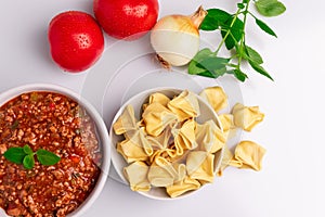 Fagottini Tortellini pasta with Bolognese also know as Bolognesa or Bolonhesa sauce in a white bowl isolated in white background