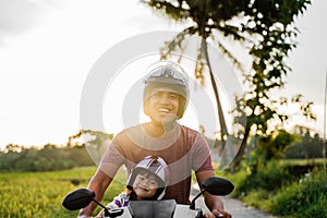 Fahter and his child enjoy riding motorcycle scooter