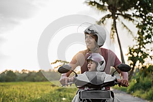 Fahter and his child enjoy riding motorcycle scooter