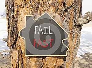 Fail fast symbol. Concept words Fail fast on beautiful black house blackboard. Beautiful tree background. Business and fail fast