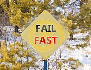 Fail fast symbol. Concept words Fail fast on beautiful yellow road sign. Beautiful forest snow blue sky background. Business and