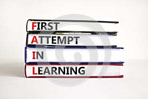 FAIL first attempt in learning symbol. Books with words FAIL first attempt in learning. Beautiful white table, white background,