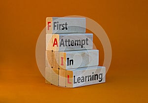 FAIL first attempt in learning symbol. Wooden blocks with words FAIL first attempt in learning. Beautiful orange table, orange