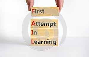 FAIL first attempt in learning symbol. Wooden blocks with words FAIL first attempt in learning. Beautiful white table, white