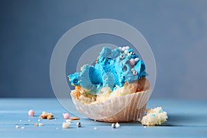 Failed cupcake on blue wooden table, closeup. Troubles happen