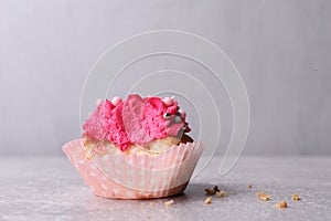 Failed cupcake with cream on light grey table, closeup. Troubles happen