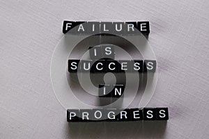 Failure is success in progress on wooden blocks. Motivation and inspiration concept