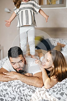 Fair-haired girl standing on her daddy`s back