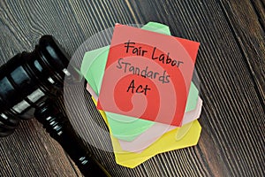 Fair Labor Standards Act write on sticky note isolated on Wooden Table. Justice/Law concept