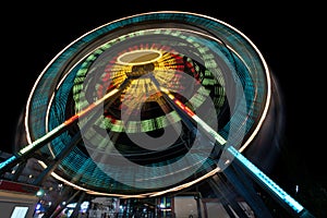 A fair ride shot with a long exposure at night - Ferris wheel in the evening, creating light streaks