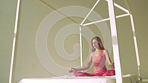 Fair-skinned blond woman making yoga pose in bed