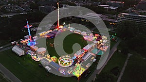 Fair during a summer sunset with illuminated fairground attractions