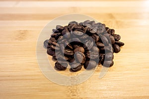 Fair trade coffee bean background on a bamboo wooden table as a breakfast, energizer, and soft commodities concept