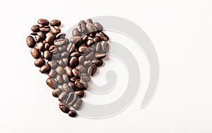 Fair trade roasted organic coffee beans shaped as a heart on whi