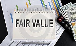 FAIR VALUE text written on notebook with chart,calculator and dollars