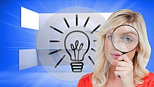 Fairhaired woman looking through a magnifying glass photo